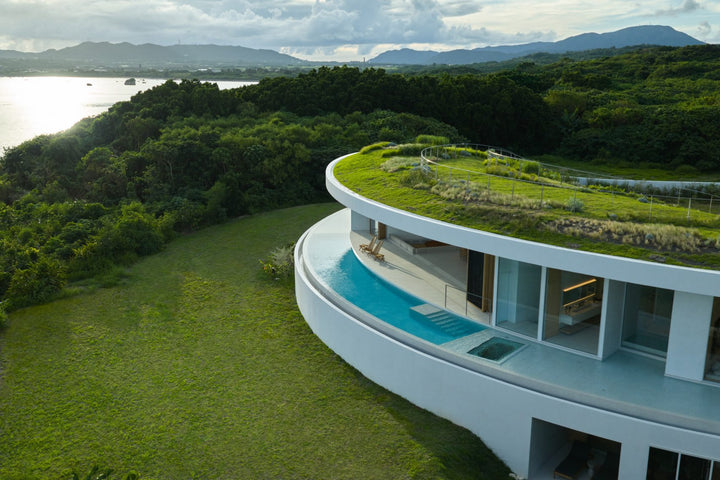 Sunken courtyard with curved concrete walls at Earth holiday home by Sou Fujimoto on Ishigaki Island, Japan